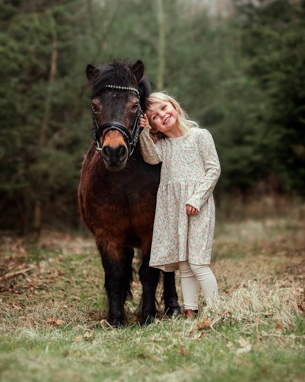 Professionel dyrefotografering i skoven. Herligt bånd og tæt kram mellem pige og pony foreviget i naturen i Jylland.